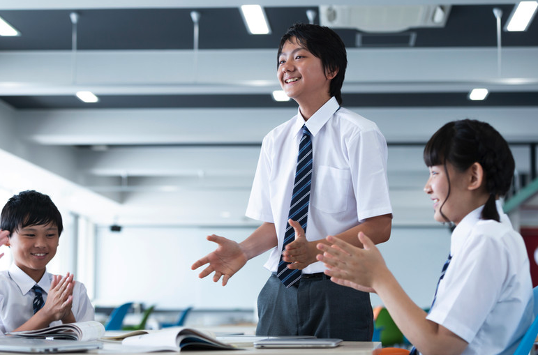 教室で自分の考えを発表する生徒